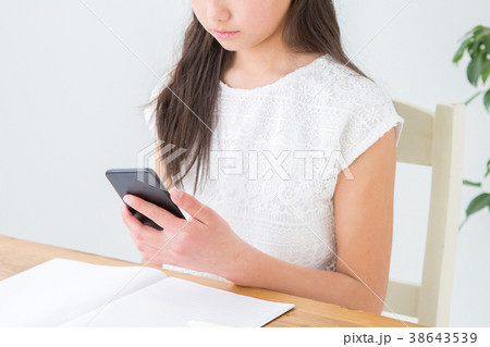 スマホを見ながら勉強する女の子 38643539