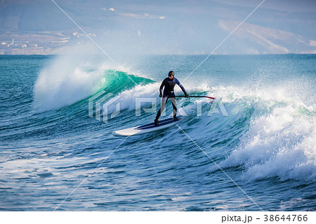Surfer on stand up paddle board ride at wave 38644766