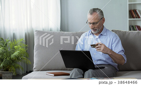 Attentive senior man sitting on couch and 38648466