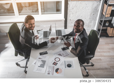 Cheerful managers are shaking hands 38656435