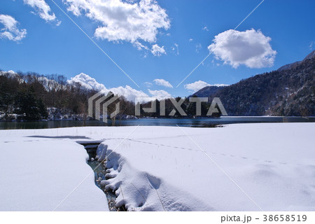 冬の奥日光 湯ノ湖 湖畔の雪と水路と青い空　b 空広め 38658519