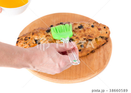 Hand greases oil on a pie. Hand greases oil on a pie. 38660589