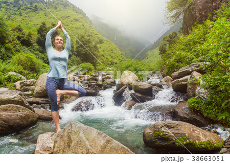 Woman in yoga asana Vrikshasana tree pose at 38663051