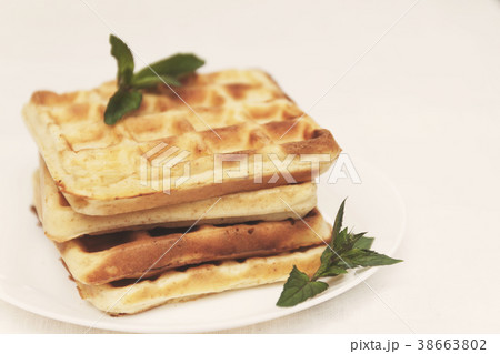 Belgian waffles with fresh mint on a white plate 38663802