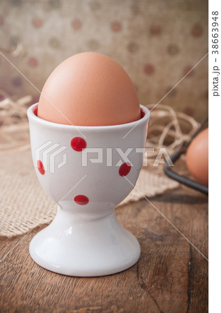 closeup of eggs with eggcup on wooden table 38663948