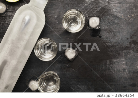 Cold vodka in shot glasses on a black background Cold vodka in shot glasses on a black background 38664254