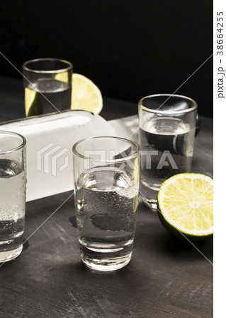 Cold vodka in shot glasses on a black background 38664255