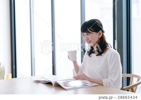 ダイニングテーブルで雑誌を見る女性 38665434