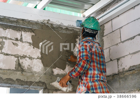 Mason plastering the concrete to build wall 38666596
