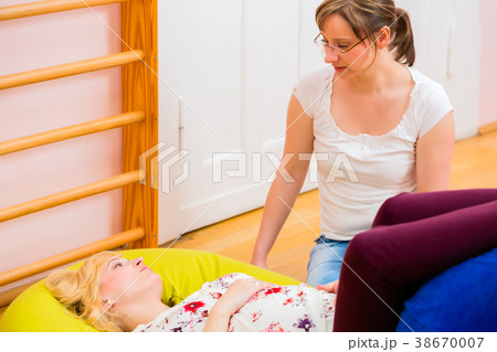 Midwife giving prenatal care for pregnant mother 38670007