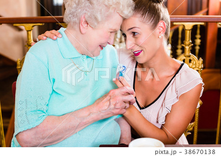 Senior woman and granddaughter at coffee in cafe Senior woman and granddaughter at coffee in cafe 38670138