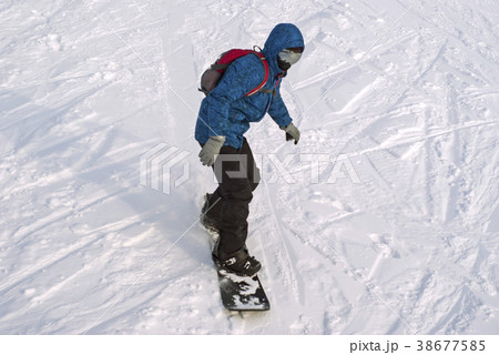 snowboarder is riding on a mountainside snowboarder is riding on a mountainside 38677585