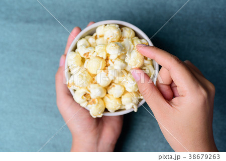 Hand picking caramel popcorn and eating 38679263