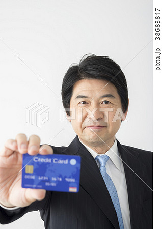 クレジットカードを見せるミドルビジネスマン クレジットカードを見せるミドルビジネスマン 38683847