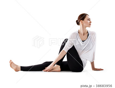 Young woman sitting on the floor and stretching. 38683956