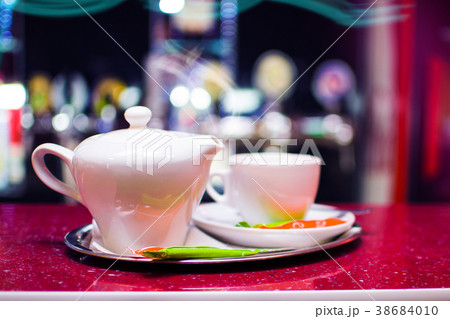 Black tea in a ceramic teapot on a tray with a cup 38684010