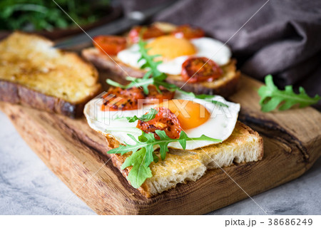 Healthy breakfast toast with egg, roasted tomato Healthy breakfast toast with egg, roasted tomato 38686249