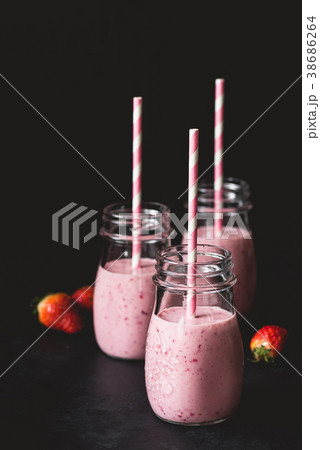 Fresh strawberry smoothies in jars with pink 38686264