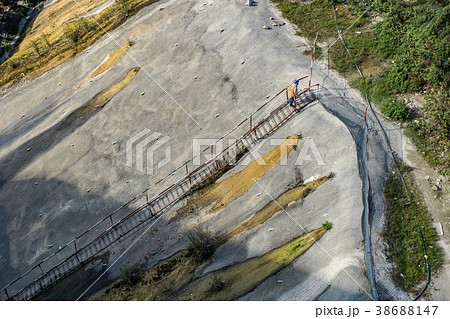 worker go up by temporary stairway on high slope 38688147