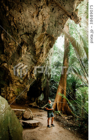 Young asian male photographer in forest - cave 38689075