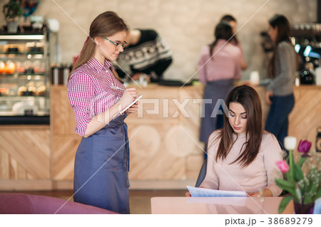 Hospitable waitress with notepapers and pencil Hospitable waitress with notepapers and pencil 38689279