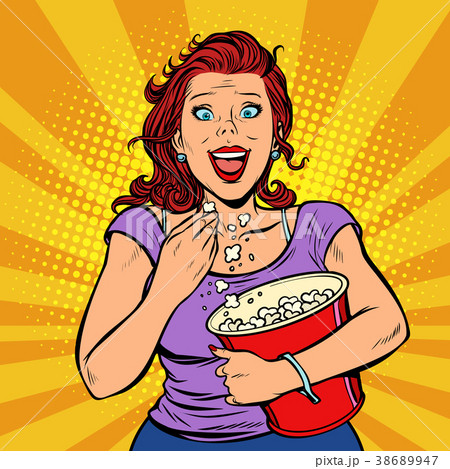 Woman watching a movie, smiling and eating popcorn Woman watching a movie, smiling and eating popcorn 38689947