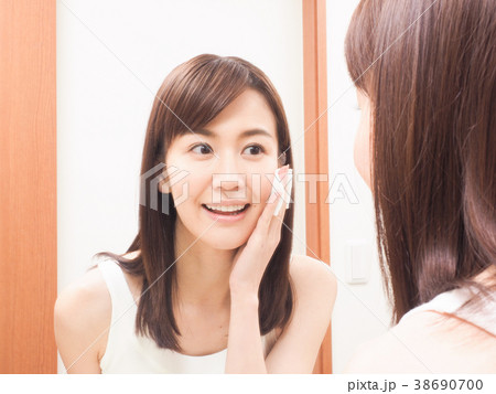 コットンを手にして鏡を見る女性 コットンを手にして鏡を見る女性 38690700