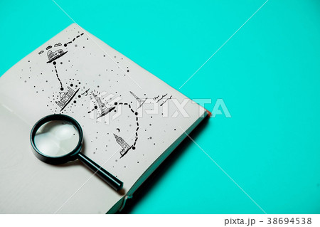 Open book with magnifier and map of travel 38694538