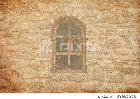 Old medieval window with lattice in brick wall 38695559