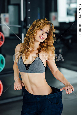 Woman with red hair shows her weight loss. 38697073