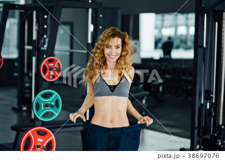 Woman with red hair shows her weight loss. 38697076