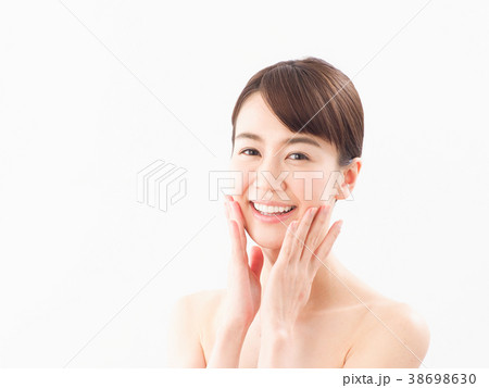 顔に手をあてて微笑む女性（ビューティー） 38698630