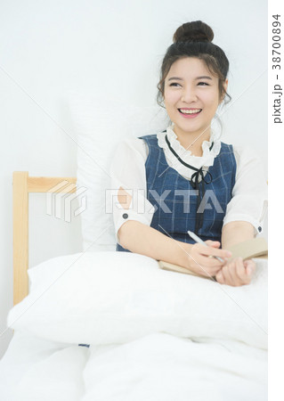 Close-Up Of pretty Woman writing on bed 38700894