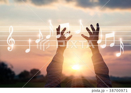 Hands touching music notes on nature background Hands touching music notes on nature background 38700971