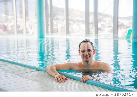 Young man relaxing on a luxury rooftop swimming 38702417