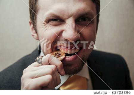 man is trying to break the bitcoin with his teeth 38702890