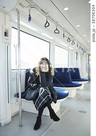 足を組む 女子大生 電車の写真素材