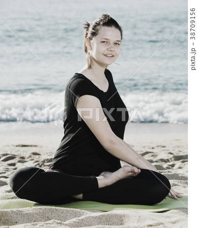 Female 20-30 years old is practicing set of stretching exercises in black T-shirt Female 20-30 years old is practicing set of stretching exercises in black T-shirt 38709156