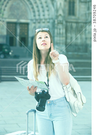 Pretty traveling girl using paper map Pretty traveling girl using paper map 38709246