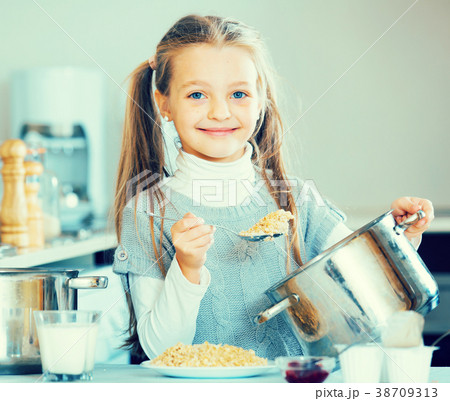Portrait of female child with tasty porridge in kitchen Portrait of female child with tasty porridge in kitchen 38709313