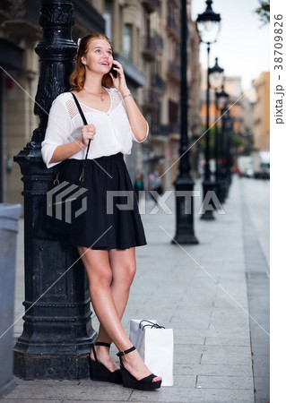 Cheerful young girl talking on mobile phone Cheerful young girl talking on mobile phone 38709826