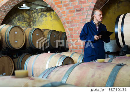 Worker taking notes in wine cellar 38710131