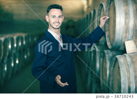 man worker wearing uniform standing and writing label to woods 38710243