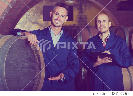 Wine makers in winery cellar 38710262