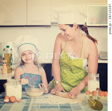 woman and her small assistant kneading paste 38710297