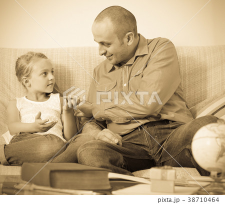 Portrait of father and little girl discussing something indoors 38710464