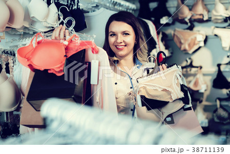 Female shopper boasting her purchases in underwear shop Female shopper boasting her purchases in underwear shop 38711139