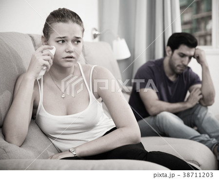 Upset girl on sofa after quarrel with husband Upset girl on sofa after quarrel with husband 38711203