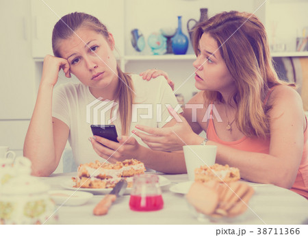female talking with sad friend with mobile 38711366