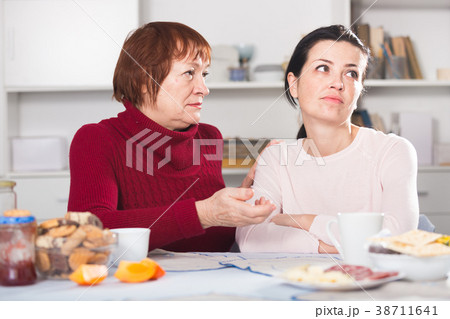 Portrait of sad mature woman talking with daughter 38711641
